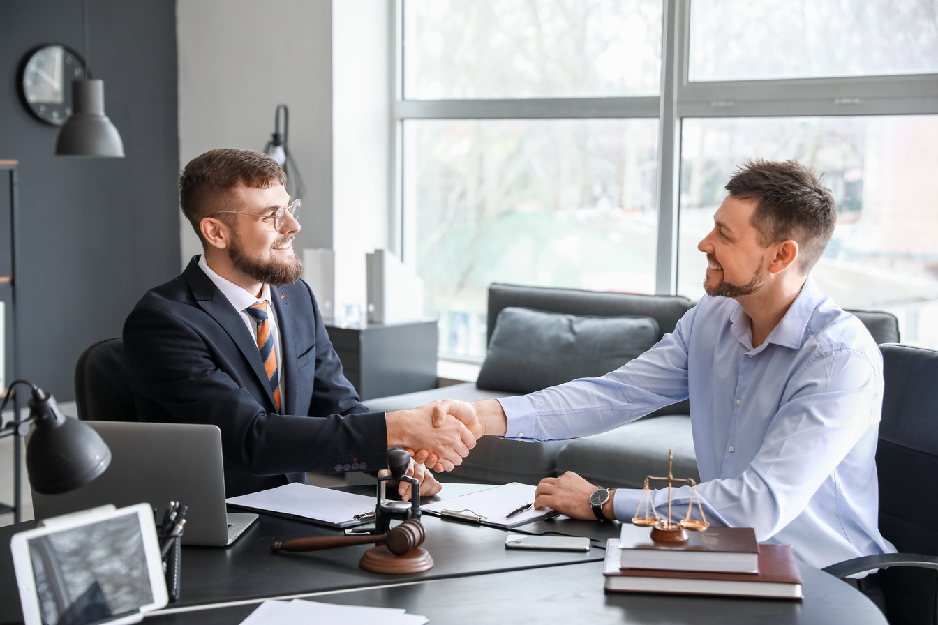 Male Lawyer with Client Shaking Hands in Office